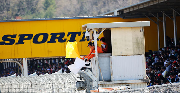 コース脇にオレンジの服を着た人がいっぱいいるよ？